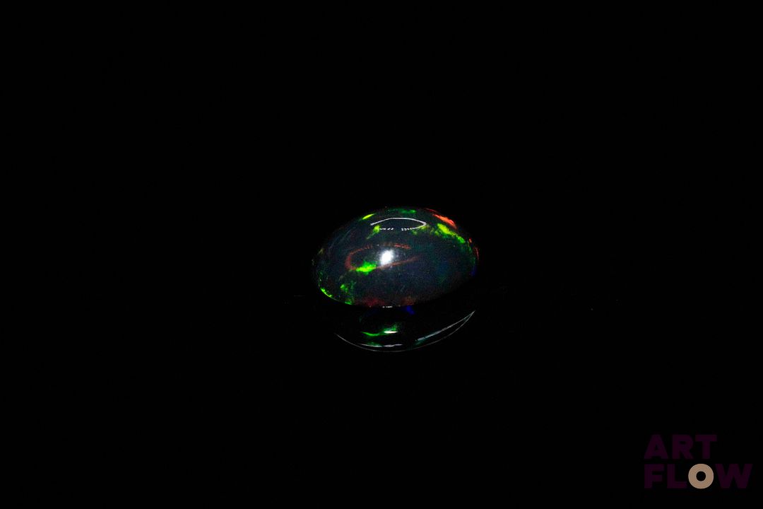Opale noire cabochon ovale. Beaux éclats de couleur. 1.13 ct. 9.0mm x 7.0mm