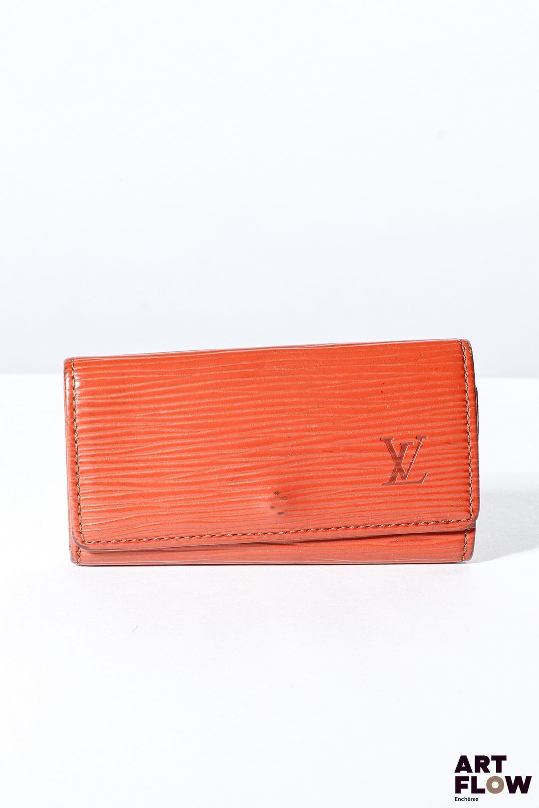 LOUIS VUITTON Porte clés en cuir épi marron, bijouterie en métal doré, fermoir à pression sous rabat. Dimensions : 6 x 10,5 cm Bon état général (quelques marques d’usage)