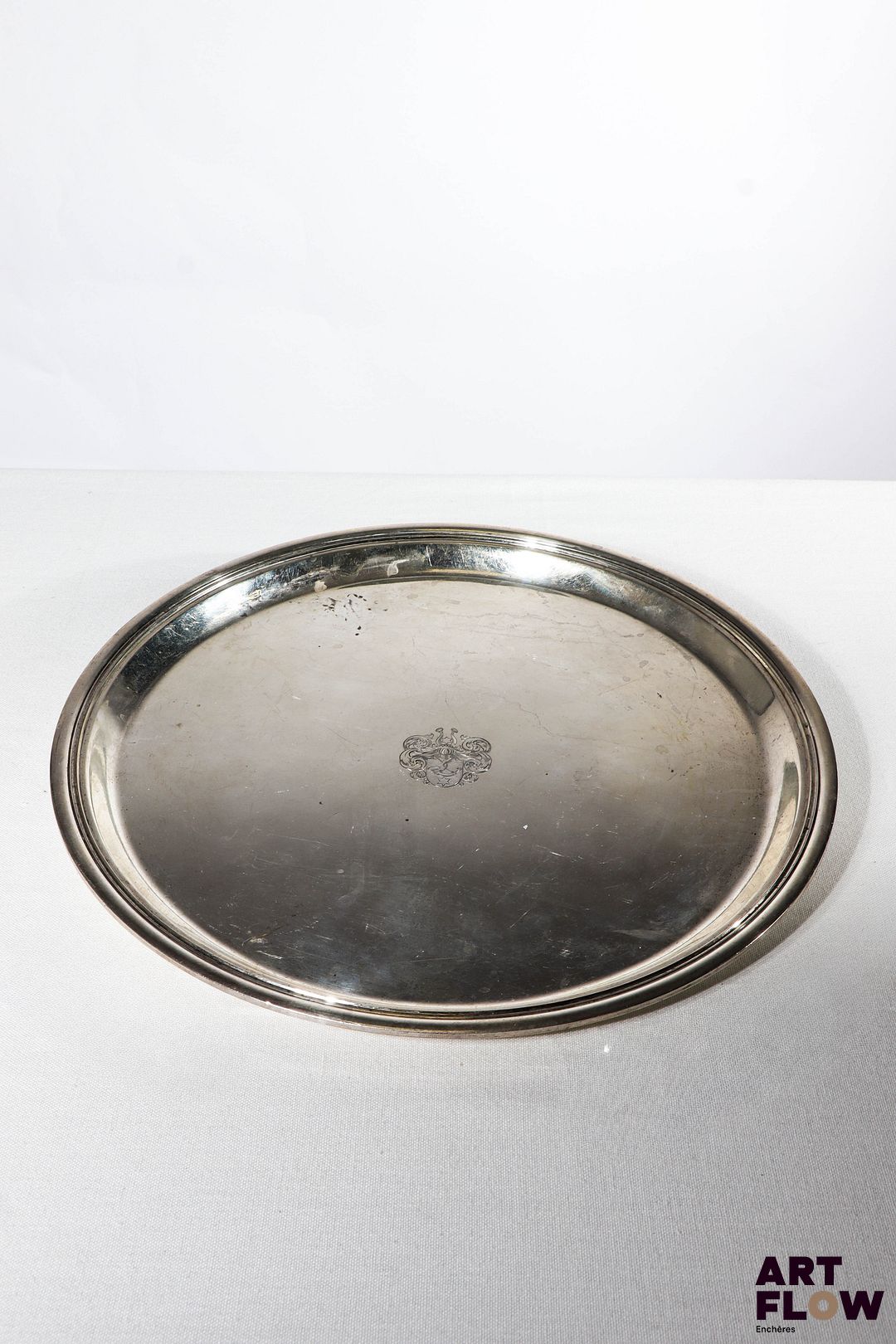 Plateau rond en argent, le centre orné d'un blason. Poids : 822,01 g D 31 cm