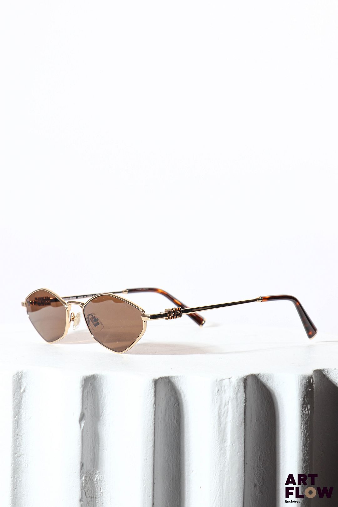 MIU MIU Paire de lunettes de soleil, verres marrons et branches en métal doré et résine imitant l'écaille Dans son étui et sa boîte d'origine (abîmée)