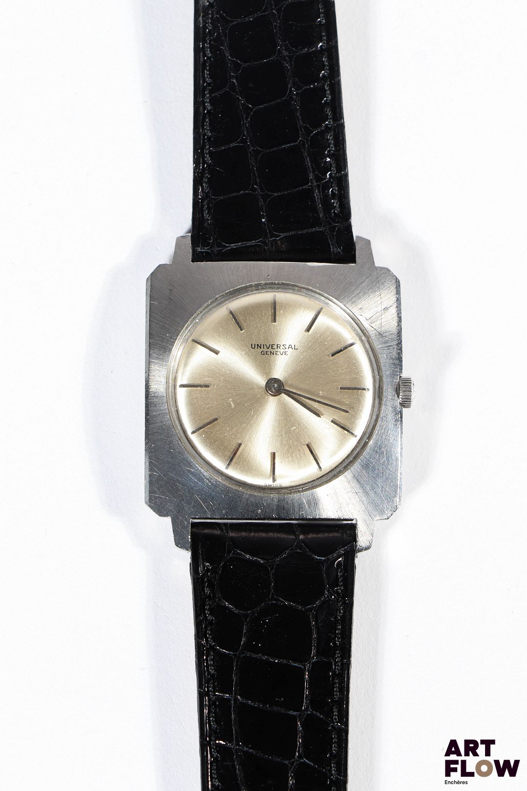 UNIVERSAL GENÈVE Montre bracelet homme en acier, à mouvement mécanique à remontage manuel, le boîtier de forme cioccolatone à cadran à fond soleillé, index bâtons, lunette soleillé, le bracelet en cuir noir. Années 1960 28 x 28mm Longueur du bracelet : 17 cm env. Référence 282162 Fondée en 1894, Universal Genève s’est imposée comme une maison pionnière du chronographe, devenue mythique grâce à des modèles iconiques comme la Compax et la Tri-Compax, symboles de l’âge d’or de l’horlogerie suisse. Bon état général (rayures sur le fond de boîte et sur le boitier) Fonctionnelle au moment de la rédaction du catalogue, révisé récemment, mécanisme non garanti.