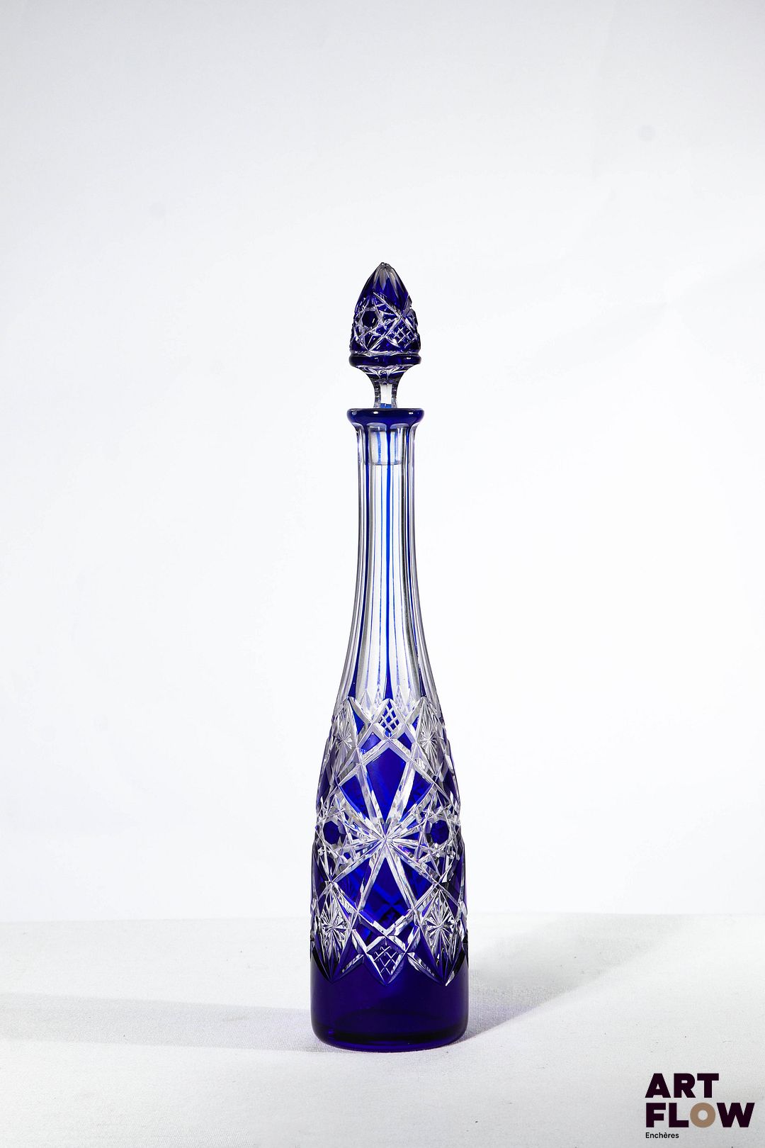 Dans le goût de Baccarat Carafe en cristal bicolore à décor géométrique gravé H 33,5 cm avec bouchon. Quelques accidents (rayures et éclat au bouchon)