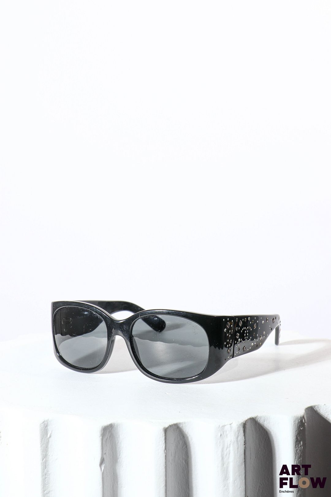 CHANEL Paire de lunettes de soleil noires Incrustées de cristaux Swarovski et ornées de monogrammes en métal argenté Dans son écrin Bon état général (quelques rayures sur les verres)