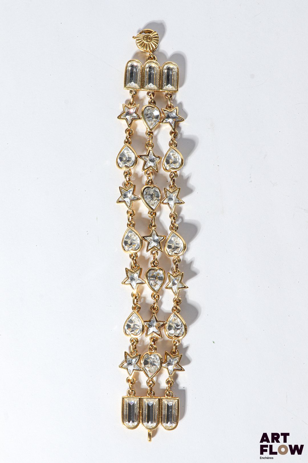 YVES SAINT LAURENT Manchette en métal doré orné de coeurs et étoiles arborants des cabochons composés de brillants Fermoir à anneau Longueur : 20 cm Signé sur le fermoir Bon état général