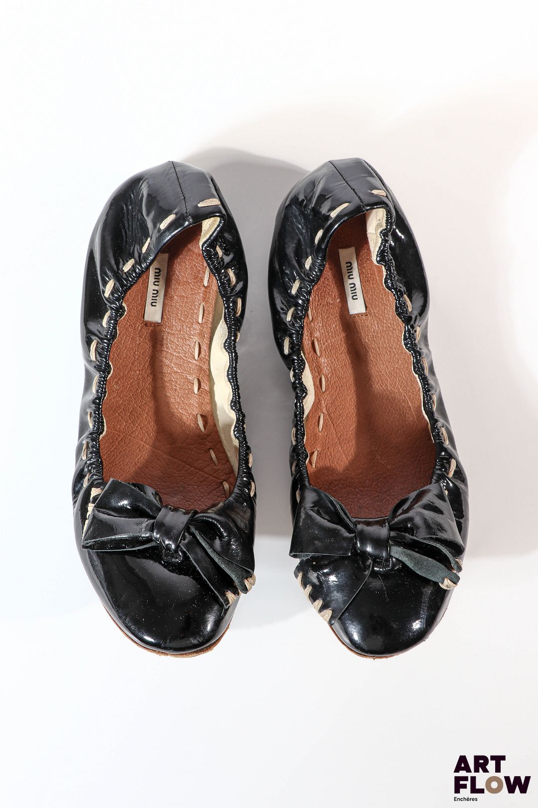 MIU MIU Paire de ballerines en cuir verni noir, ornées d'un noeud, surpiqûres beiges Pointure 35 État d'usage