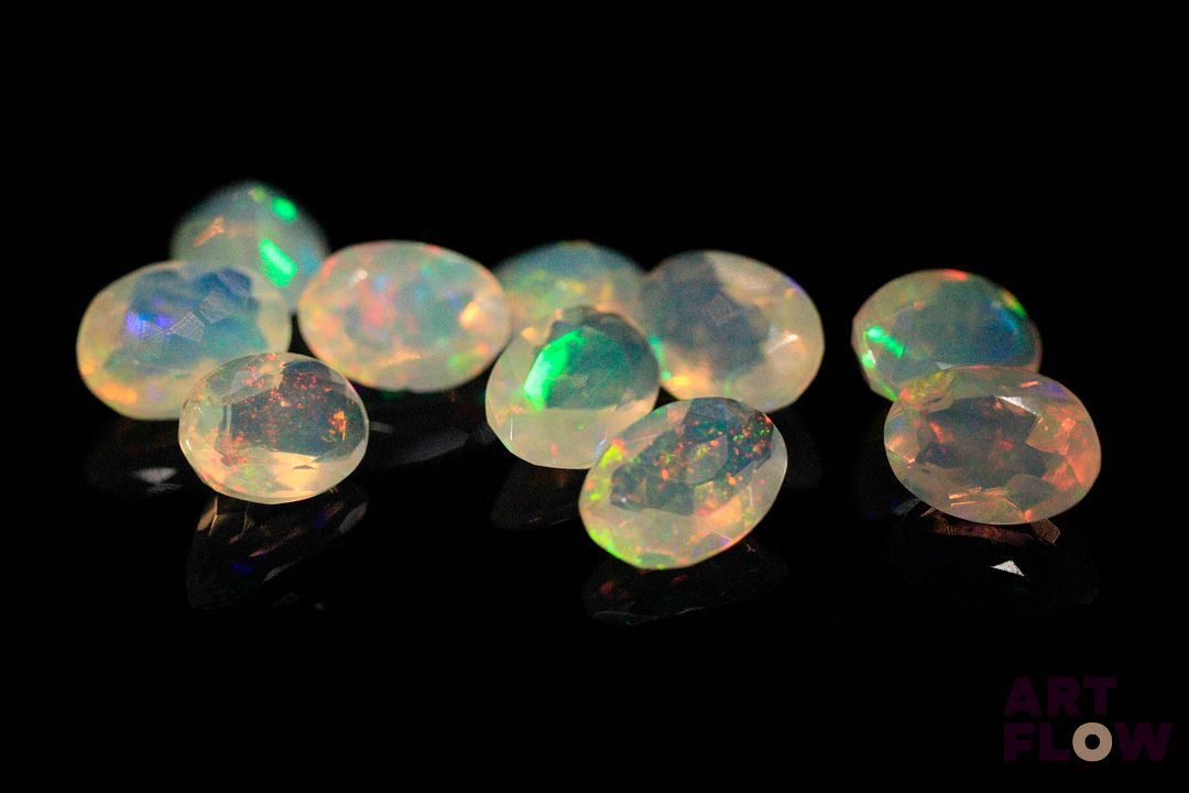 Dix opales facettées blanches ovales. Beaux éclats de couleur. 5.07 cts. Dims. moy.: 7.0mm x 5.0mm