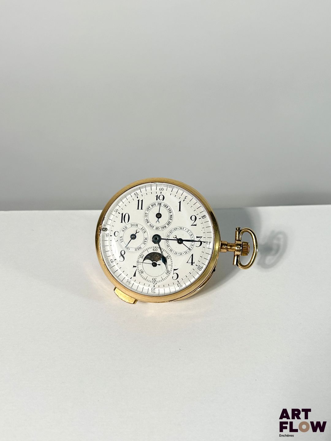 Montre de gousset à quantième annuel et répétitions minutes, travail Italien, XIXe s Cadran émaillé blanc, index en chiffres arabes peints, aiguilles bleuies, capot et boîtier en or 750 Complication comprenant quatre sous-compteurs dont le quantième annuel, phase de lune et petite seconde à 6h D. 52 mm, poids brut : 129,32 g Bon état général (quelques ébréchures sur le verre, une restauration sur le boîtier avec une trace de brasure) Cette montre peut être datée entre 1809 et 1819 grâce à la présence d’un poinçon partiellement effacé représentant une tête de coq, visible sur la tige. Ce poinçon, utilisé par les bureaux de garantie des départements du 1er septembre 1809 au 16 août 1819, attestait pour l’ensemble de l’objet le respect du titre légal minimum de 750 millièmes.