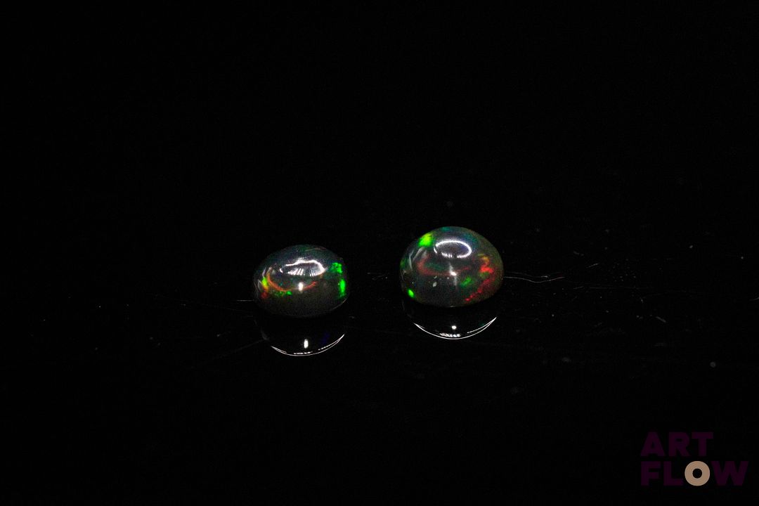 Appairage d'opales noires cabochons ronds. Beaux éclats de couleur. 0.86 ct. Diam. moy.: 6.0mm