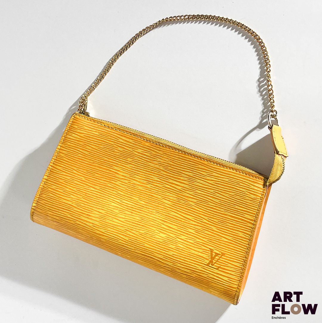 LOUIS VUITTON Pochette en cuir jaune, bijouterie en métal doré, fermeture éclair. Dimensions : H. 12,5 x L. 21 cm