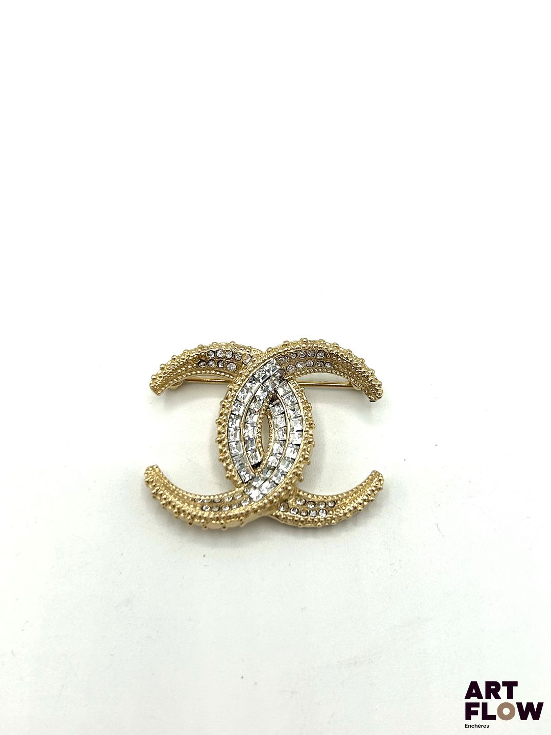 CHANEL Broche en métal doré pavée de strass Signée H. 3 cm x L. 3,5 cm