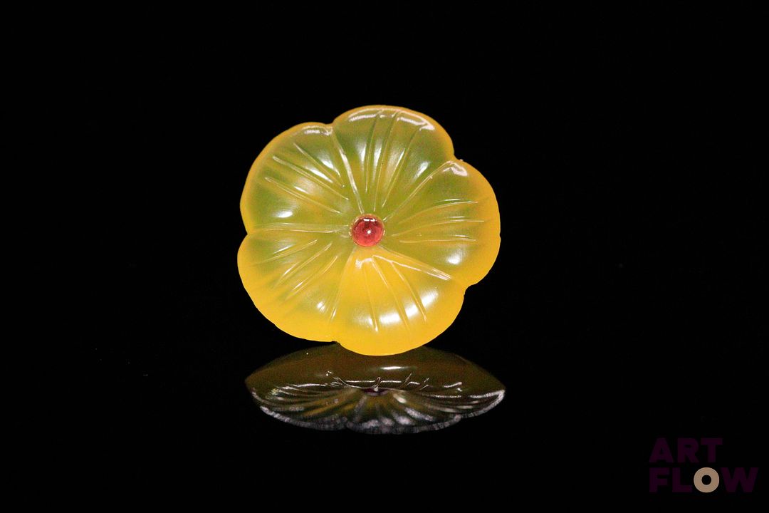 Calcédoine fleur ronde centrée d'un petit saphir orangé. 10.90 cts. 19.7mm