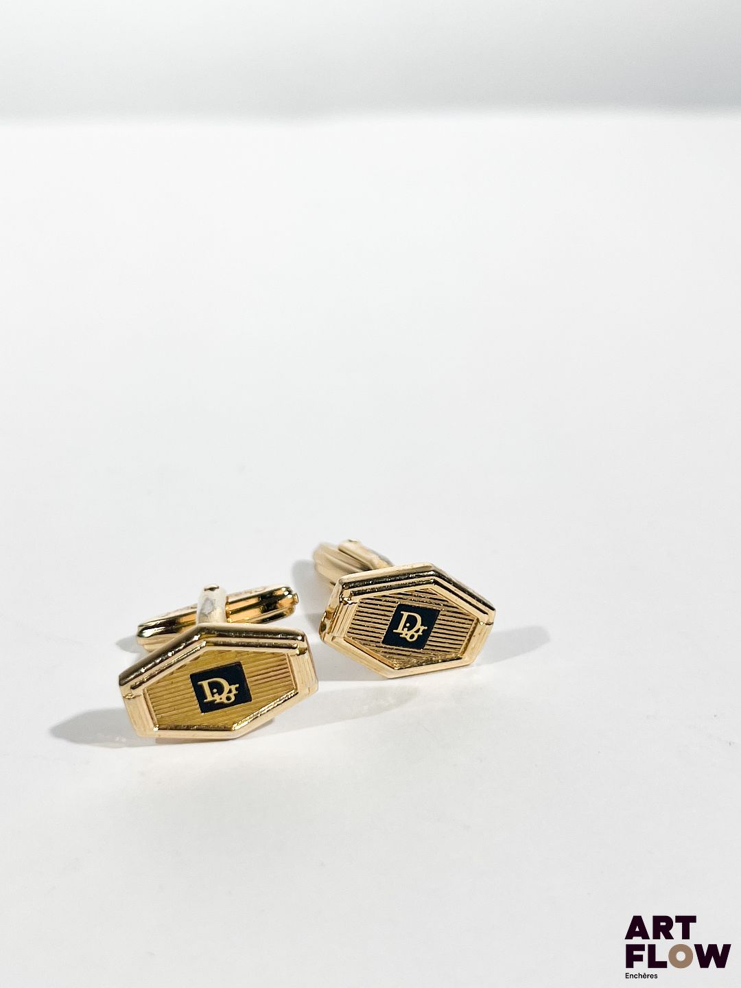Christian DIOR Paire de boutons de manchette en métal doré Boutons de manchette : 2 x 1,5 cm env. On y joint une pince a cravate