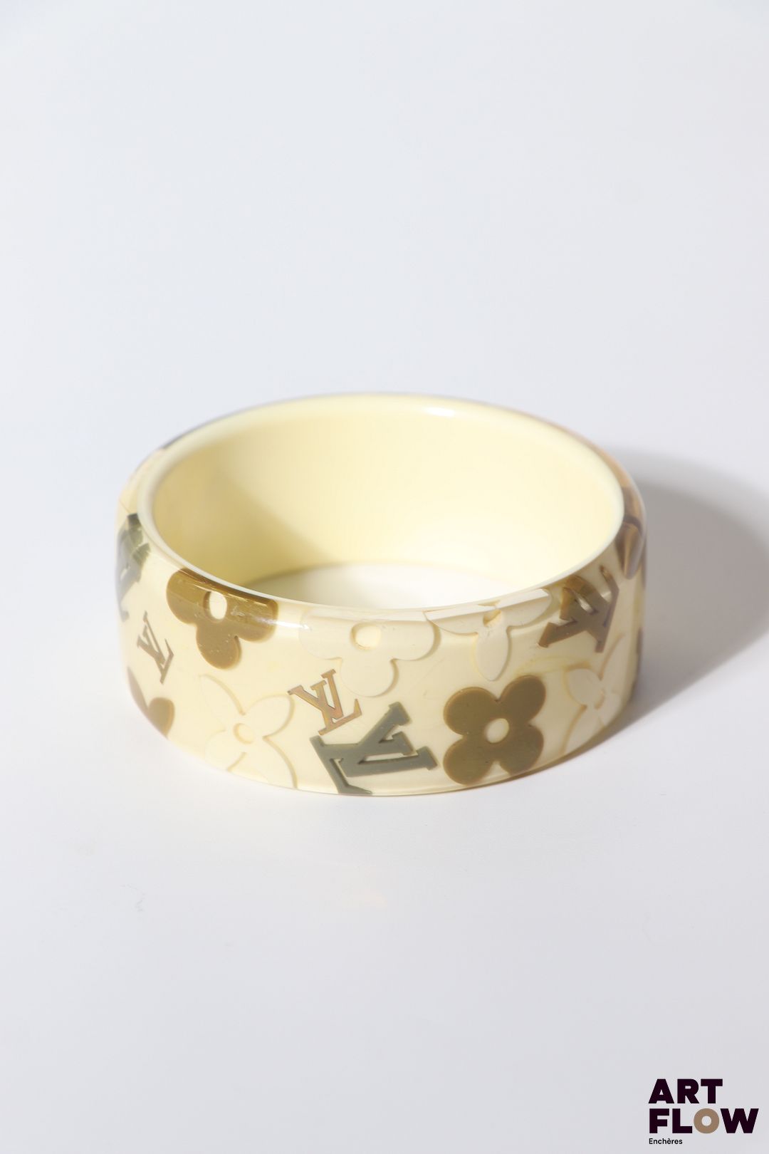 LOUIS VUITTON Bracelet "Inclusions" en résine a fond crème et motifs gris et taupe. Diamètre intérieur : 6,8 cm H. : 3 cm Traces internes à noter.