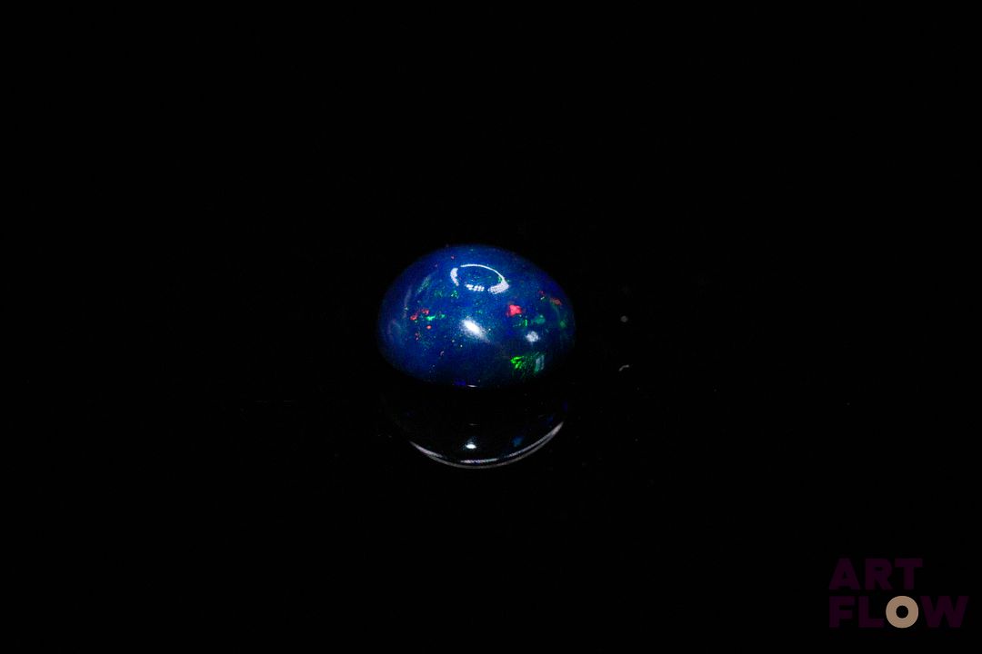 Opale noire cabochon rond. Beaux éclats de couleur, dominante bleue. 1.33 ct. 8.0mm