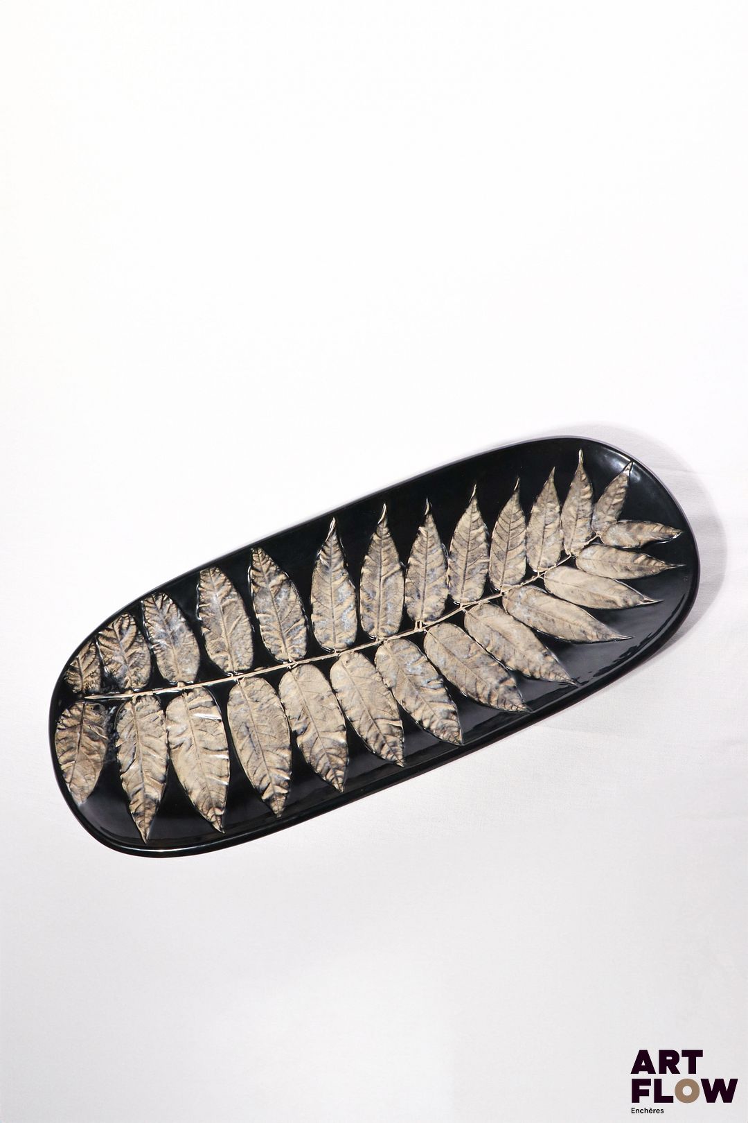 POL CHAMBOST (1906-1983) Plat 865 de forme ovale, en faience émaillée polychrome à décor de fougères. Incisé au revers "Poterie Pol Chambost, 865, Made in France" 63 x 26 x 4 cm Bibliographie : Philippe Chambost, "Pol Chambost, Sculpteur-Céramiste 1906-1983", Somogy Editions d'Art, Paris, 2006, modèle similaire p. 78 ; p. 157