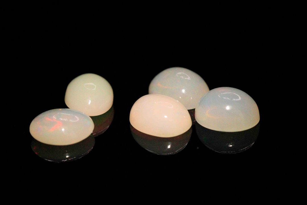 Cinq opales blanches cabochons ovales. 6.08 cts. Dims. moy.: 9.0mm x 7.0mm