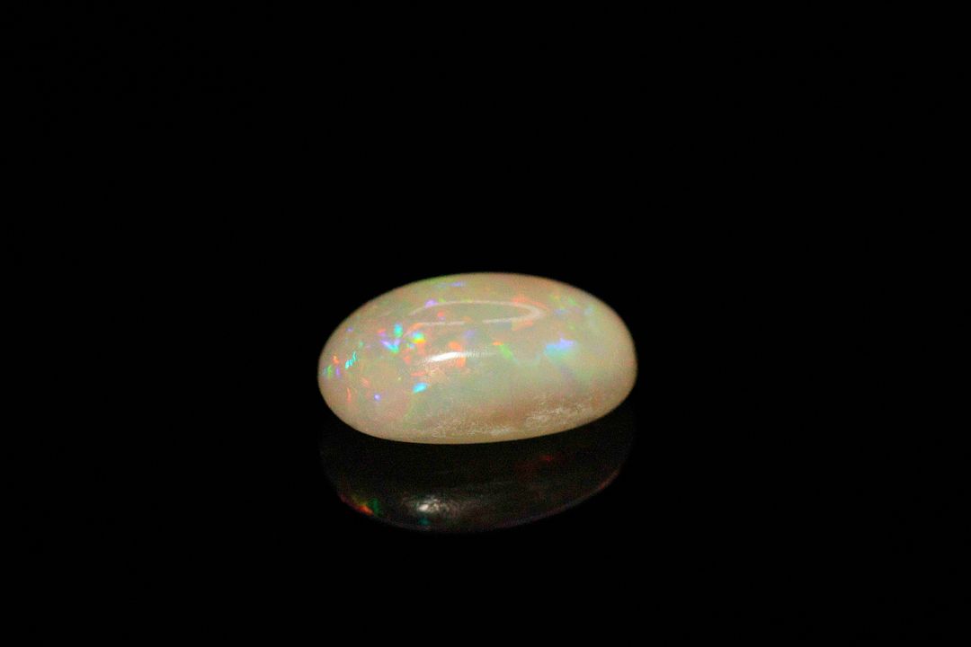 Opale blanche cabochon ovale. Probablement Ethiopie, beaux éclats de couleur. 2.90 cts. 12.0mm x 8.0mm