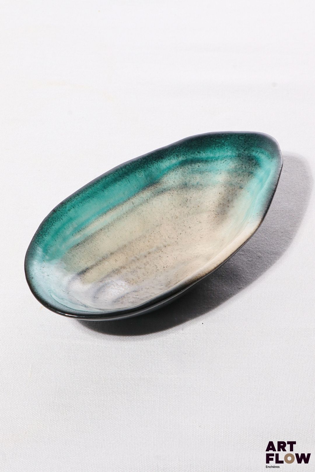 POL CHAMBOST (1906-1983) Coupe 1026 "Coquillage" en faience émaillée à couverte polychrome, l'intérieur dans les tons bleus et nacre, l'extérieur noir. Incisé "1056" et monogrammé "PC". 19,5 x 10 x 4 cm Bibliographie : Philippe Chambost, "Pol Chambost, Sculpteur-Céramiste 1906-1983", Somogy Editions d'Art, Paris, 2006, modèle similaire p. 80
