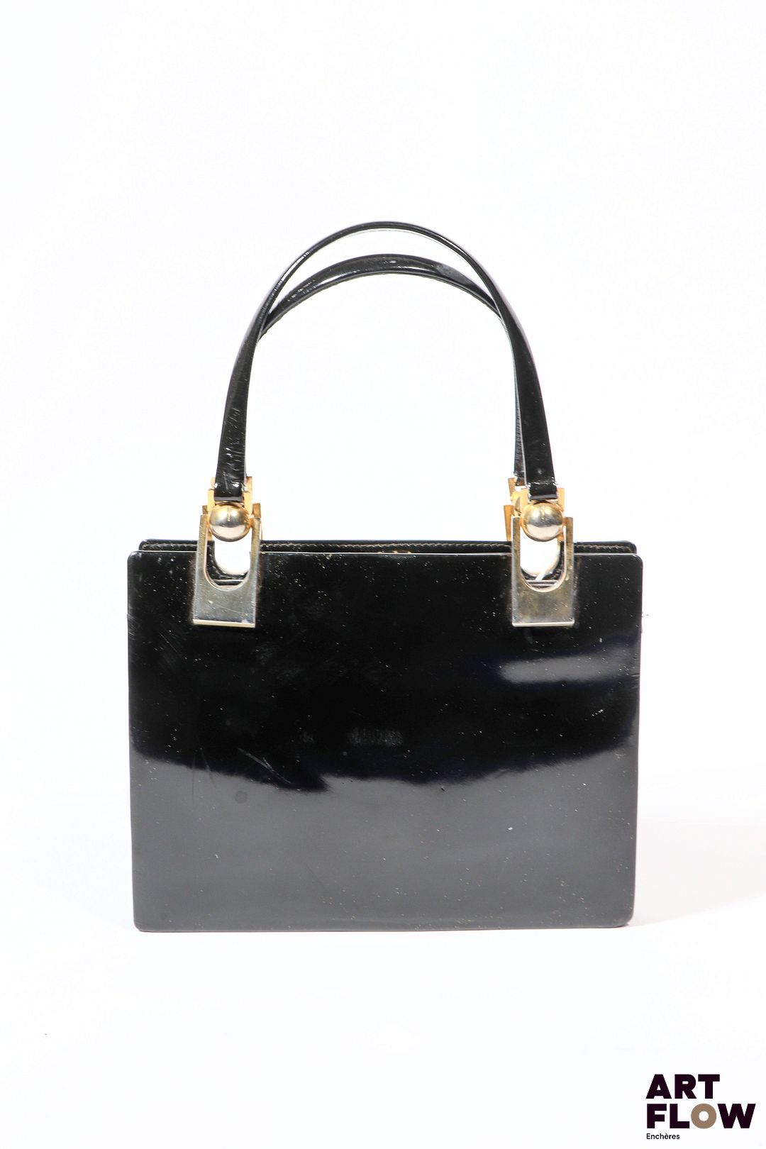 Charles JOURDAN par CESARE PICCINI Sac à main en cuir verni noir et bijouterie en metal doré, à 3 soufflets, l'intérieur pourvu d'un miroir. Dimensions : 17 x 21 cm (sans les anses). Rayures d'usage, traces