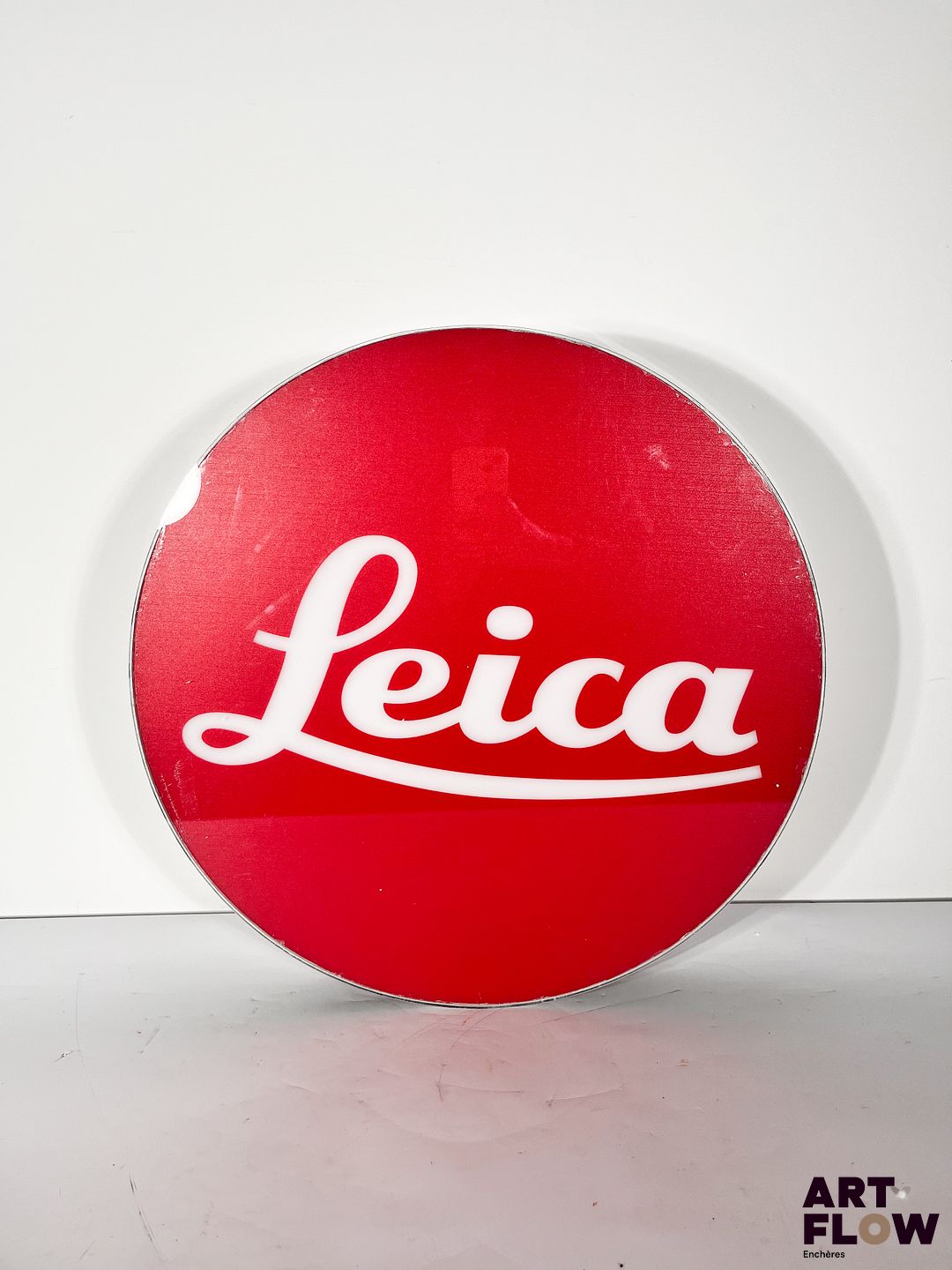 Enseigne lumineuse publicitaire sur plexiglas Leica. Dimensions : 53 x 35 cm Fonctionnelle - État général excellent. Fourni avec son alimentation murale.