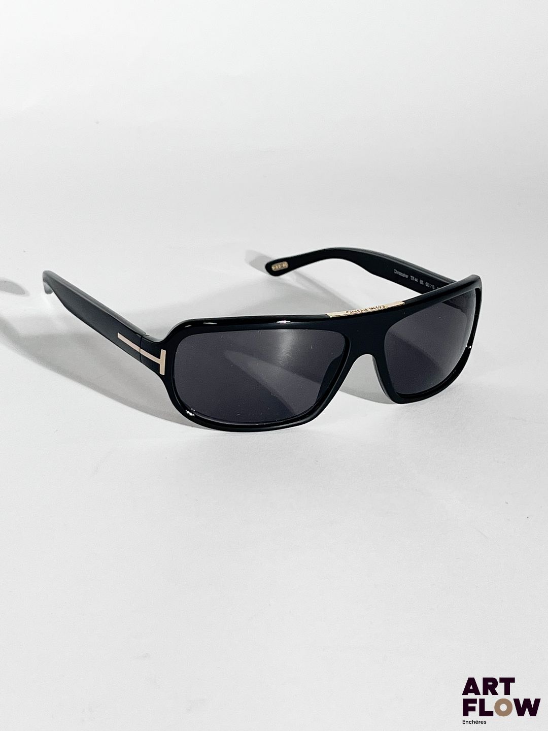 TOM FORD Paire de lunettes de soleil noires, bijouterie en métal doré. Dimensions : H. 4 x L. 14 cm