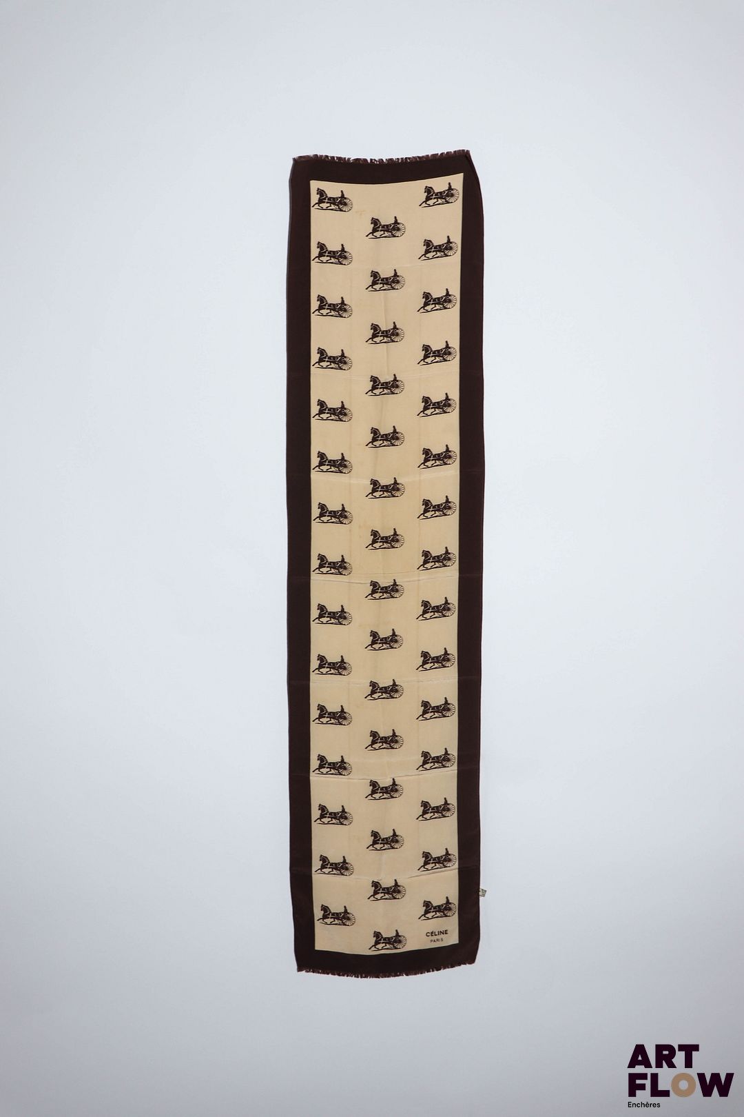 CÉLINE Paris Foulard en soie crème à décor de calèches marron chocolat. 110 x 28 cm env. Petites traces.