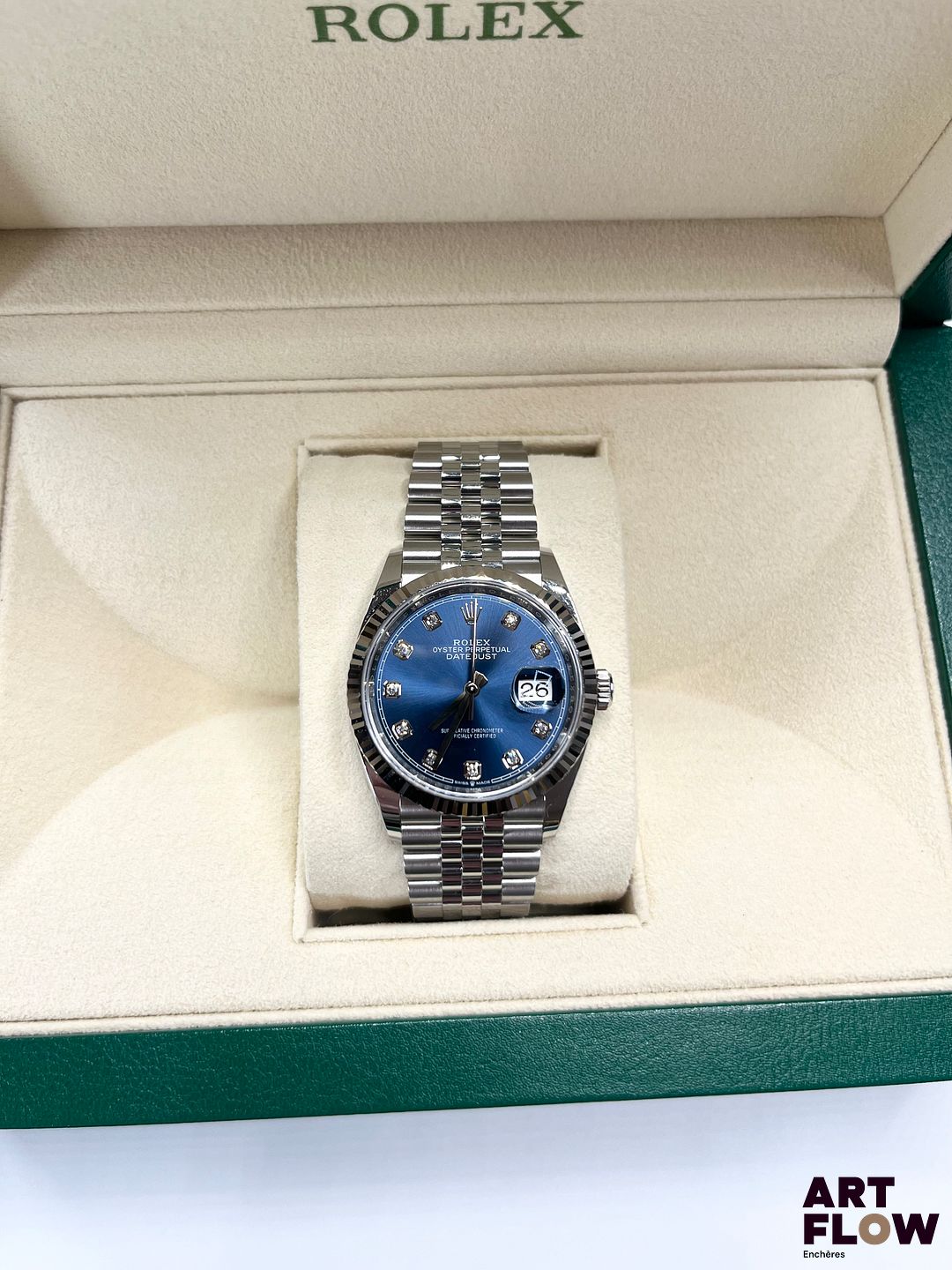 ROLEX Montre bracelet homme en acier, modèle Oyster Perpetual Datejust 36, à mouvement mécanique à remontage automatique, le boîtier de forme ronde à cadran à fond soleillé bleu, index points sertis de diamants, lunette cannelée en or blanc, guichet date à 3h, seconde centrale, le bracelet Jubilée poli-brossé. Années 2022 Diamètre 36mm Référence 126234 Introduite en 1945, la Rolex Datejust marque une étape majeure dans l’histoire de l’horlogerie. Elle est la première montre-bracelet automatique étanche à afficher la date dans un guichet. En 1953, Rolex ajoute la célèbre loupe Cyclope pour améliorer la lisibilité. Élégante et technique, la Datejust est devenue un modèle emblématique et intemporel. Neuve de stock (aucune trace d'usage, jamais portée) Fourni avec son set complet comprenant boîte, sur boîte, garantie, tags d'origine et manuel d'utilisation. Garantie datée de 2022 et donc encore valable jusqu'en 2027 Fonctionnelle au moment de la rédaction du catalogue, mécanisme non garanti. En raison de le l'état, la montre n'a pas été ouverte et le mécanisme n'a donc pas été vérifié. Expert : AFB Expertises horlogerie