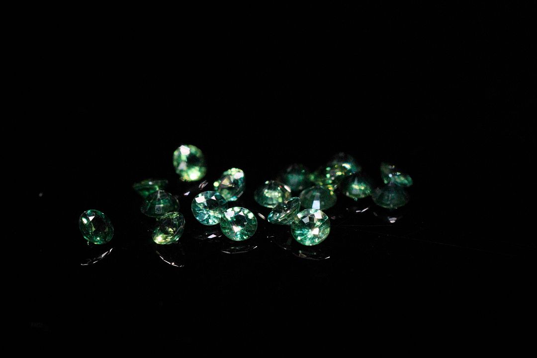 Dix-huit saphirs verts ronds. Jolie couleur. 2.74 cts. Diam. moy.: 3.0mm