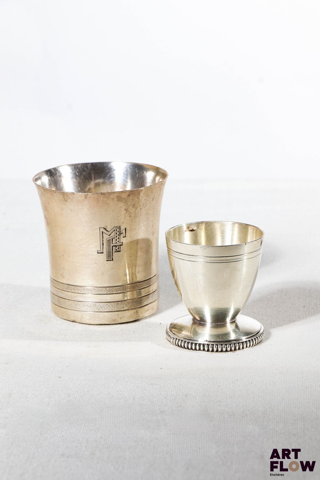 Une timbale en argent massif poinçon Minerve. Poids : 83,15 g. On y joint un coquetier en métal argenté.