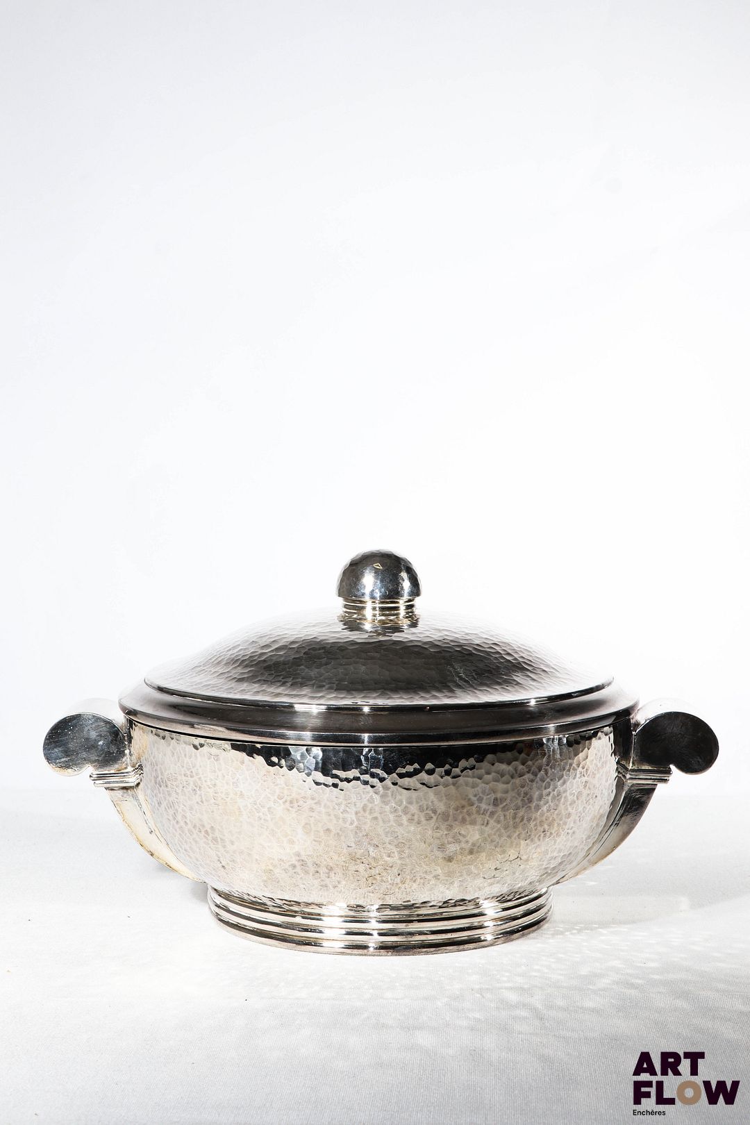 Jean DESPRES (1889-1980) Légumier couvert en métal argenté martelé reposant sur un talon. Signature à la pointe en dessous. H. 17,5 cm. Longueur. 32 cm environ. Très bon état général malgré quelques très légers défauts (petites rayures d'usage).
