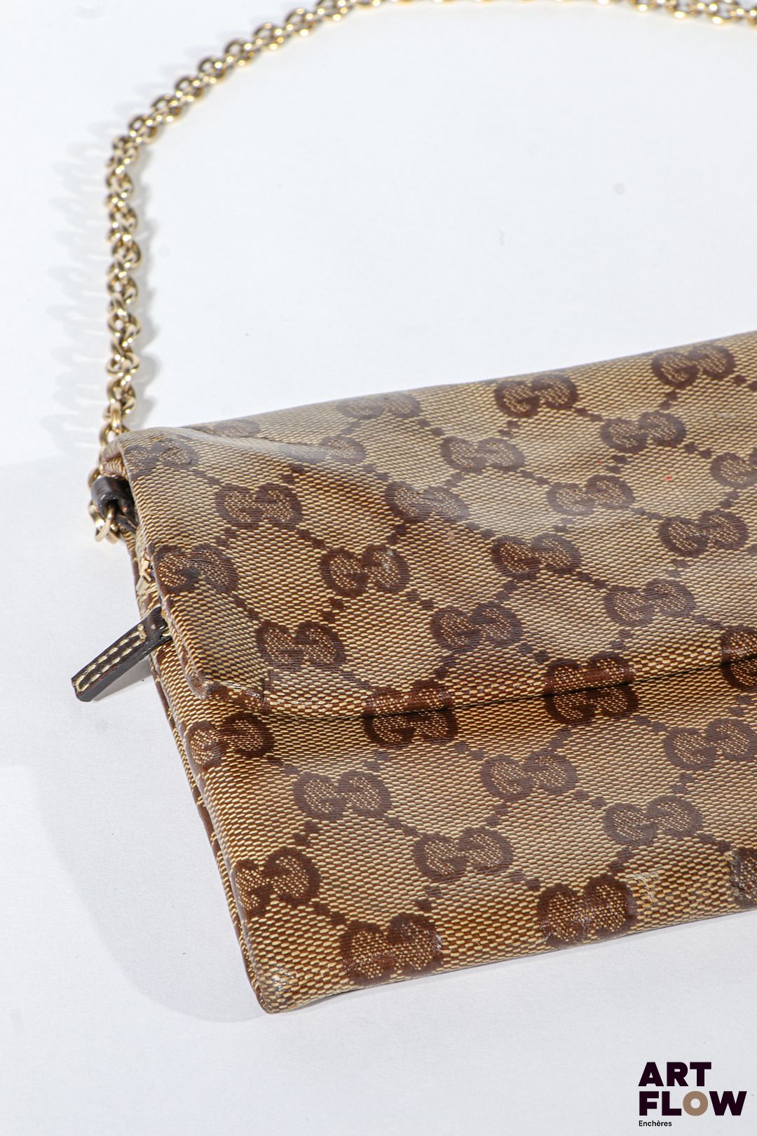 GUCCI Petit sac pochette en toile enduite monogrammée, bijouterie en métal doré, fermeture éclair. Dimensions : 14 x 19 cm