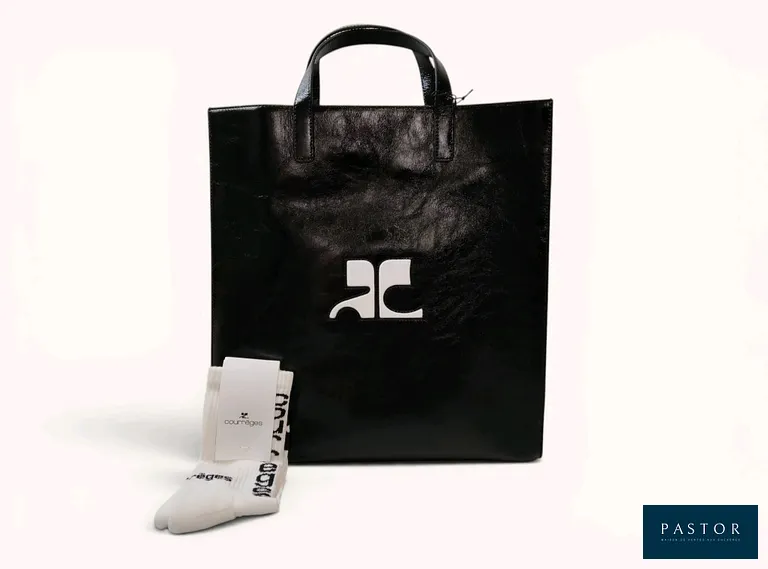 COURRÈGES. Lot composé d'un tote bag "Heritage naplack" en cuir de vachette noir aspect froissé et verni, doublure intérieure en lin mélangé beige, bandoulière réglable et amovible, logo incrusté sur la face avant, H.37 x L.34,5 x P. cm, et d'une paire de chaussette griffée de la marque, P.39/41. NEUFS avec étiquettes  - TVA Récupérable