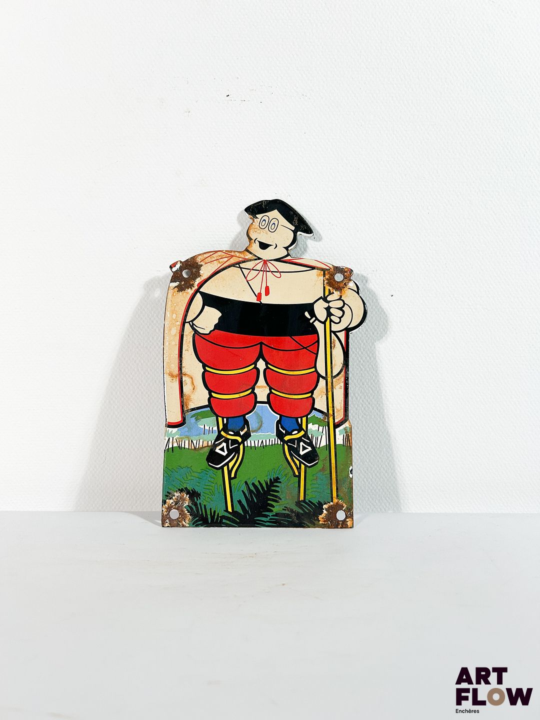 Plaque émaillée d'après Michelin - bonhomme Michelin portant des échasses Dimensions : 22 x 12 cm Petits éclats et traces de rouille - moderne