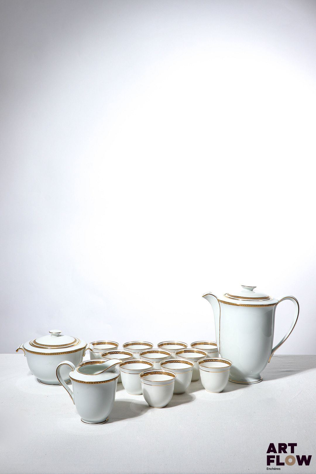 LIMOGES Bernardaud Partie de service à dessert et à café en porcelaine à décor en dorure et motifs géométriques comprenant : - 12 assiettes plates - 12 assiettes creuses - 12 assiettes - 2 navettes - 12 tasses - 1 pot à sucre - 1 pot à lait - 1 saucière - 1 soupière couverte - 1 saladier - 5 plats de service Bon état général malgré quelques légers défauts (petits fêles et petites ebrechures sur certaines pièces)