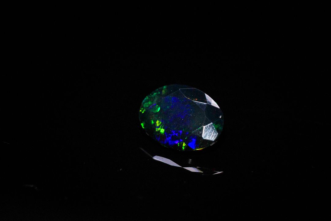 Opale facettée noire ovale. Beaux éclats de couleur. 1.17 ct. 10.2mm x 7.4mm
