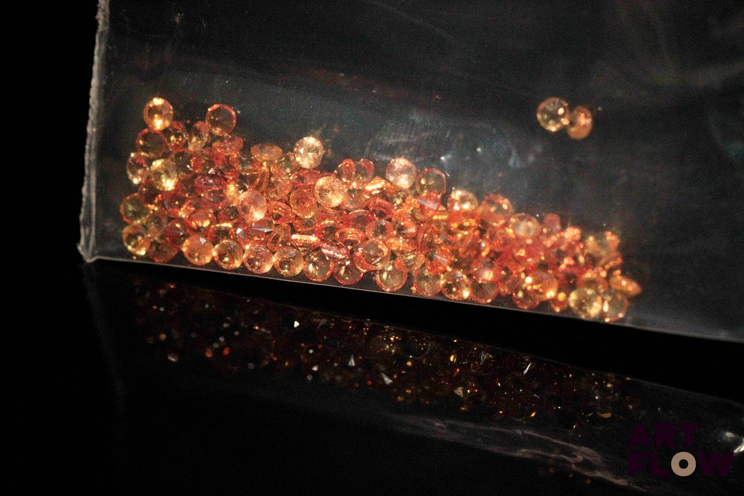 Cent dix saphirs oranges ronds. 3.23 cts. Diam. moy.: 1.7mm