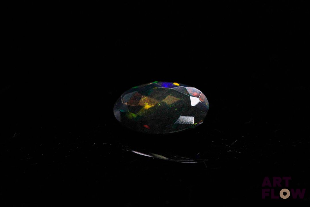 Opale facettée noire ovale. Beaux éclats de couleur, dominante verte. Probablement traitée. 2.00 cts. 13.2mm x 8.0mm