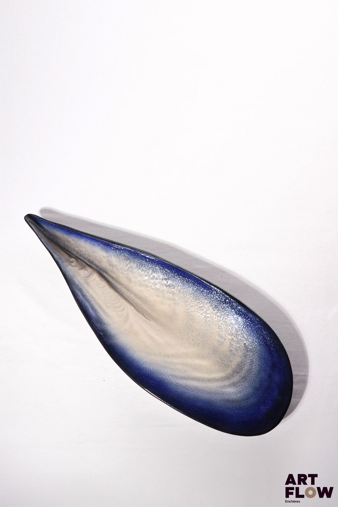POL CHAMBOST (1906-1983) Importante coupe 859 "Coquillage" en faience émaillée à couverte polychrome dans les tons bleu et blanc à l'intérieur et noire à l'extérieur. Incisé au revers"859, M.M. Poterie Pol Chalbost, France" Bibliographie : Philippe Chambost, "Pol Chambost, Sculpteur-Céramiste 1906-1983", Somogy Editions d'Art, Paris, 2006, modèle similaire p. 81
