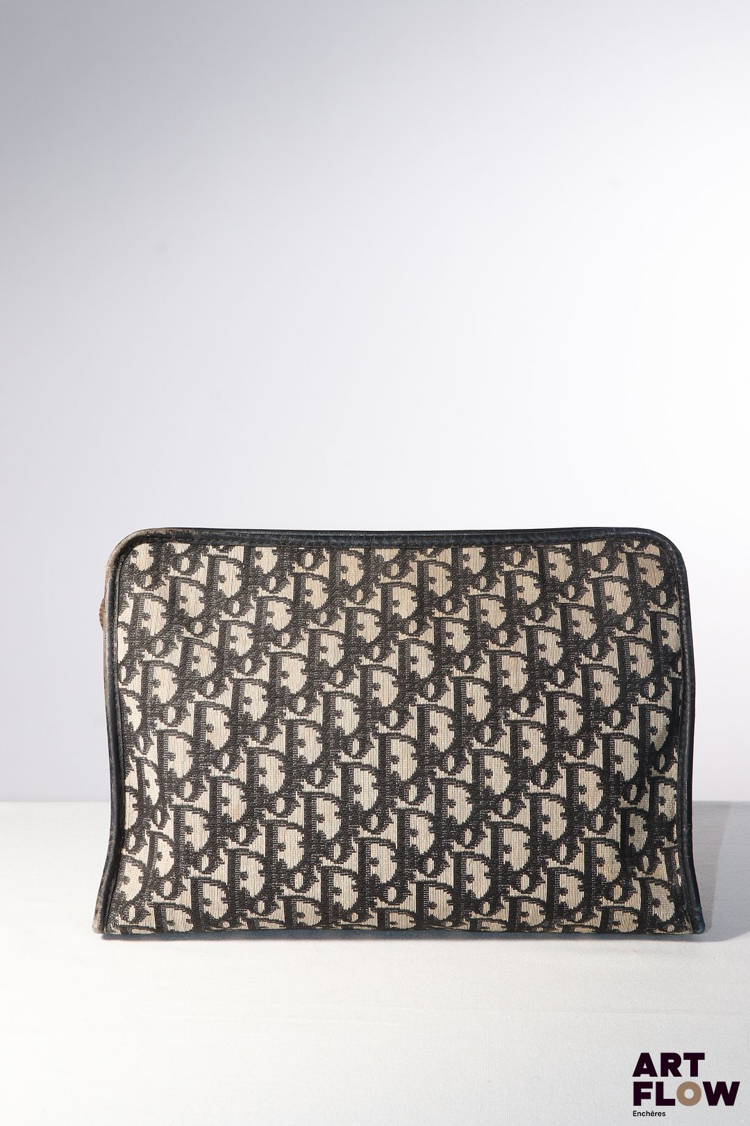 CHRISTIAN DIOR Vanity en toile monogrammée beige et noir en oblique. Fermeture à glissière. Intérieur en toile enduite beige. H. 21 x L. 30 x P. 9,5 cm. Bon état général malgré quelques défauts (usures d'usage).