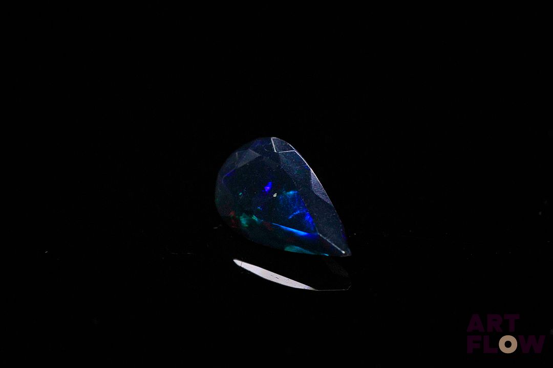 Opale facettée noire poire. Beaux éclats de couleur, dominante bleue. 1.12 ct. 12.5mm x 7.2mm