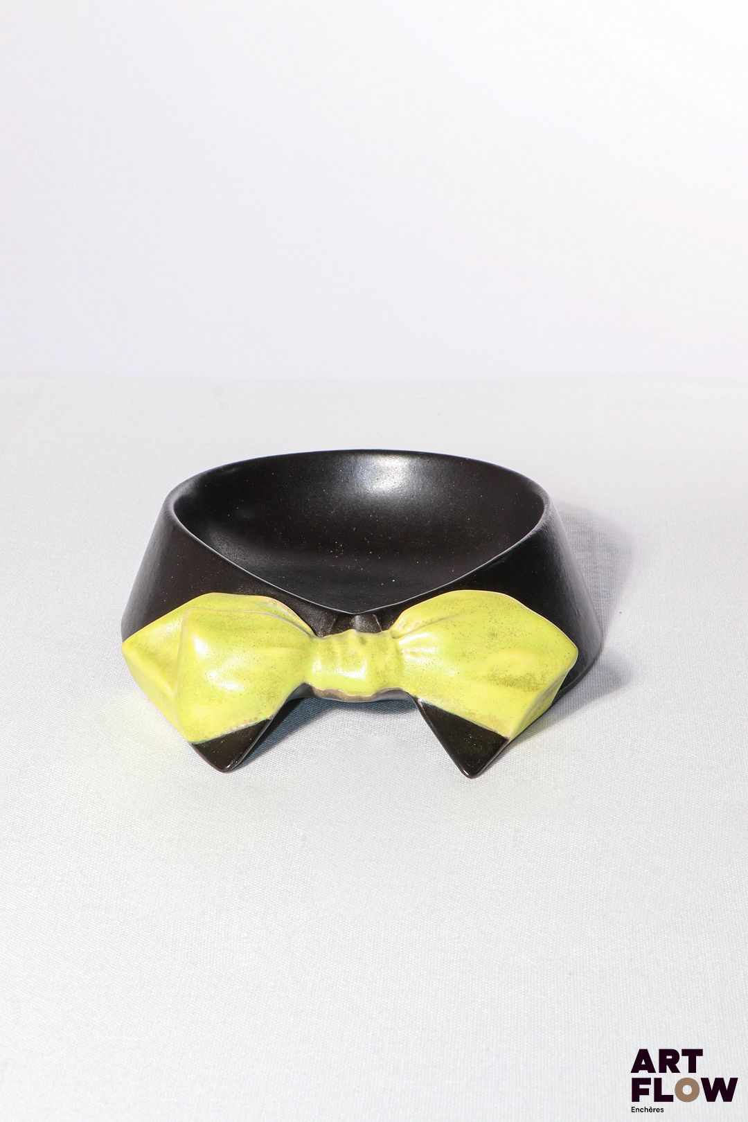 POL CHAMBOST (1906-1983) Rare vide-poches 2078 en faience émaillée figurant un col de chemise et nœud papillon, à couverte noire et jaune. Incisé au revers "2078, Pol Chambost, Made in France" 17,5 x 15 x 4 cm