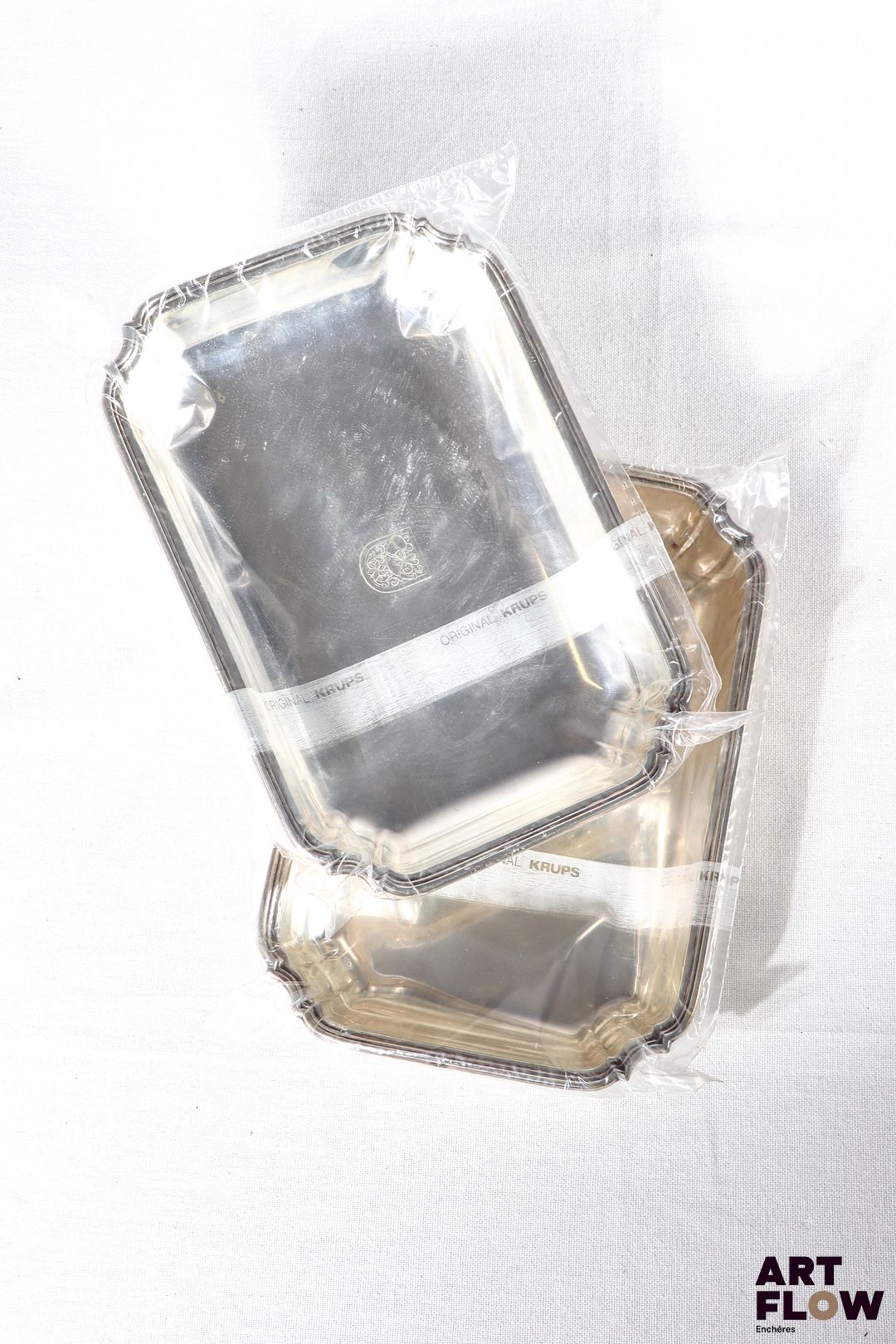 Deux plats rectangulaires en argent, l'aile légèrement chantournée et à décor de filets. Blason. Poids brut : 238 g et 234 g. Dimensions : 20,5 x 14 cm environ