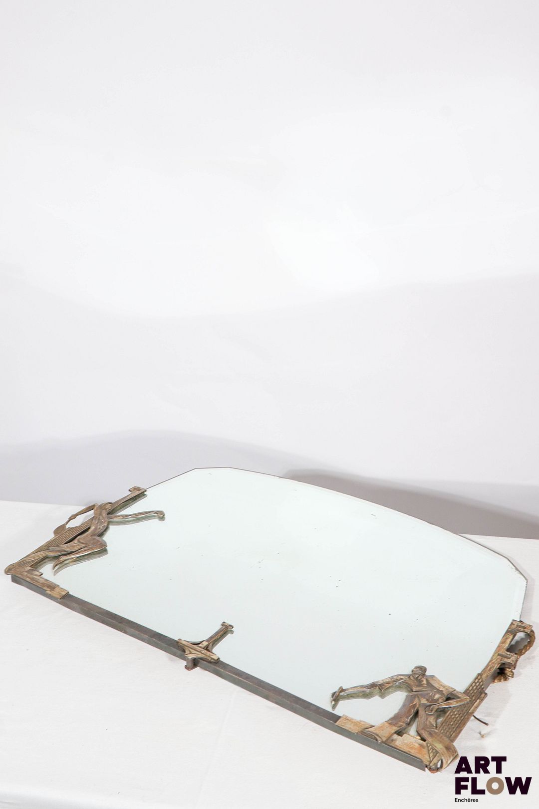 Georges Marius BORETTI (XXeme) Miroir à encadrement en bronze argenté représentant des joueurs de tennis. Circa 1930. 49 x 79 cm. Bon état général malgré quelques défauts (piqûres, petit éclat sur la glace et usures)
