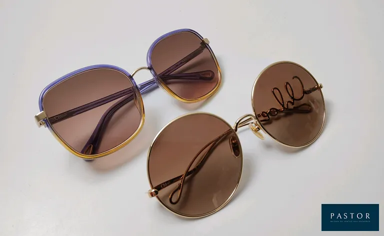 CHLOÉ. Lot composé de deux paires de lunettes de soleil comprenant un modèle "CH0329S" en métal doré, et un modèle bicolore "CH0031S". Parfait état, modèles pouvant présenter quelques micro-rayures, sans boîte - TVA Récupérable