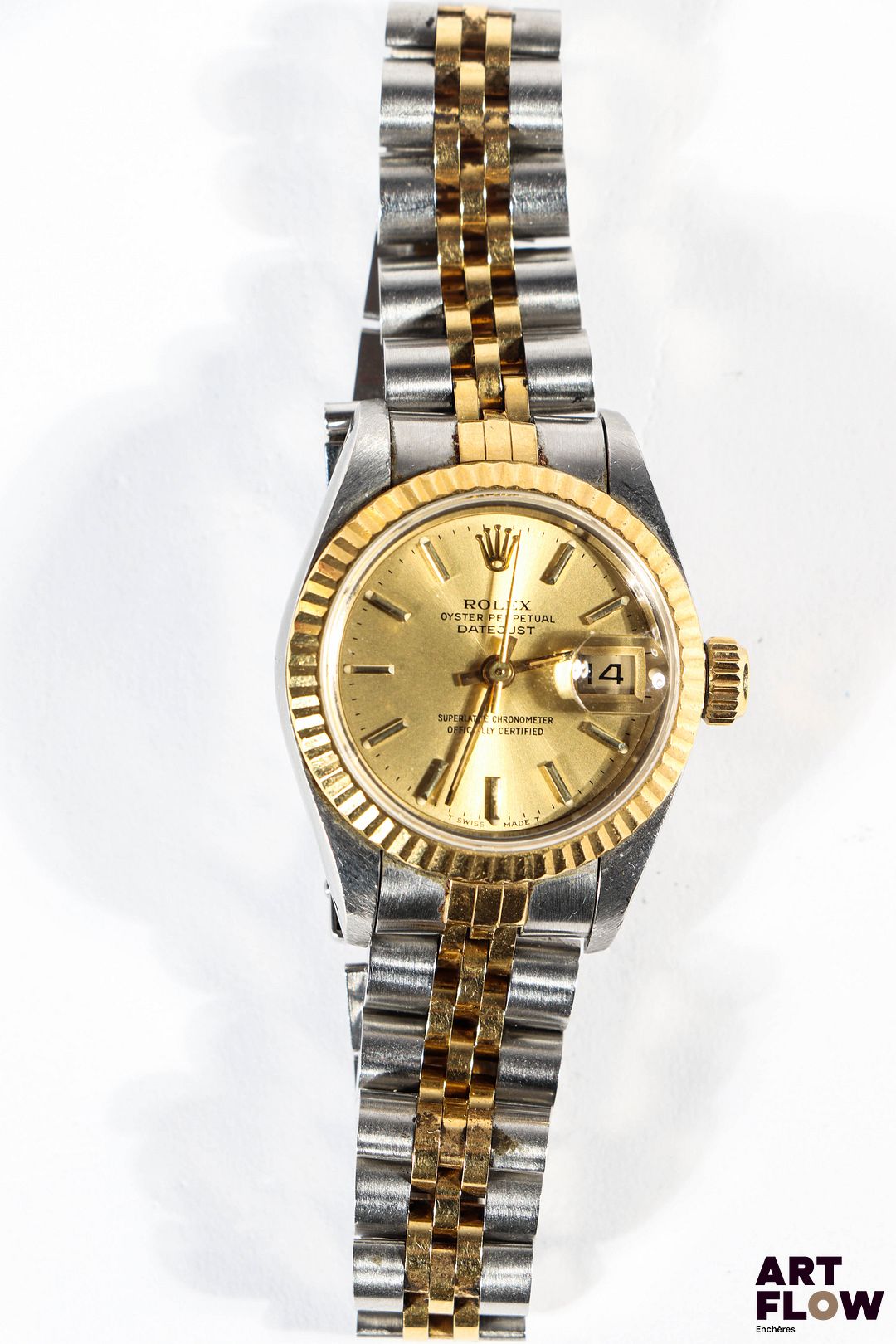 ROLEX Montre bracelet de dame, modèle Datejust, en or jaune 750/°° et acier, à mouvement mécanique à remontage automatique, le boîtier rond brossé à cadran à fond de doré, index bâtons, lunette cannelée en or jaune, bracelet jubilée. Années 1992 D. 26mm Longueur du bracelet : 16 cm env. Référence 69173 Poids brut : 57,5 gr Lancée en 1945, la Datejust est la première montre-bracelet à afficher la date automatiquement dans un guichet, symbole d’innovation et d’élégance intemporelle chez Rolex. Excellent état général. Fournie avec son set complet comprenant boîte, sur boîte, garantie, facture et tags d'origine. Fonctionnelle au moment de la rédaction du catalogue, mécanisme non garanti. Expert : AFB Expertises horlogerie