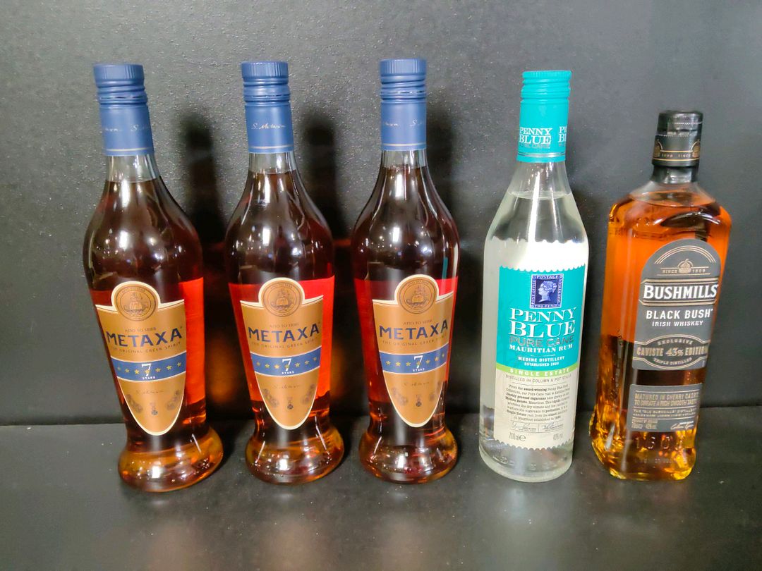 Lot de 5 bouteilles de spiritueux : 3 liqueurs Metaxa seven stars, 1 rhum Penny Blue, 1 whisky Bushmills Black Bush