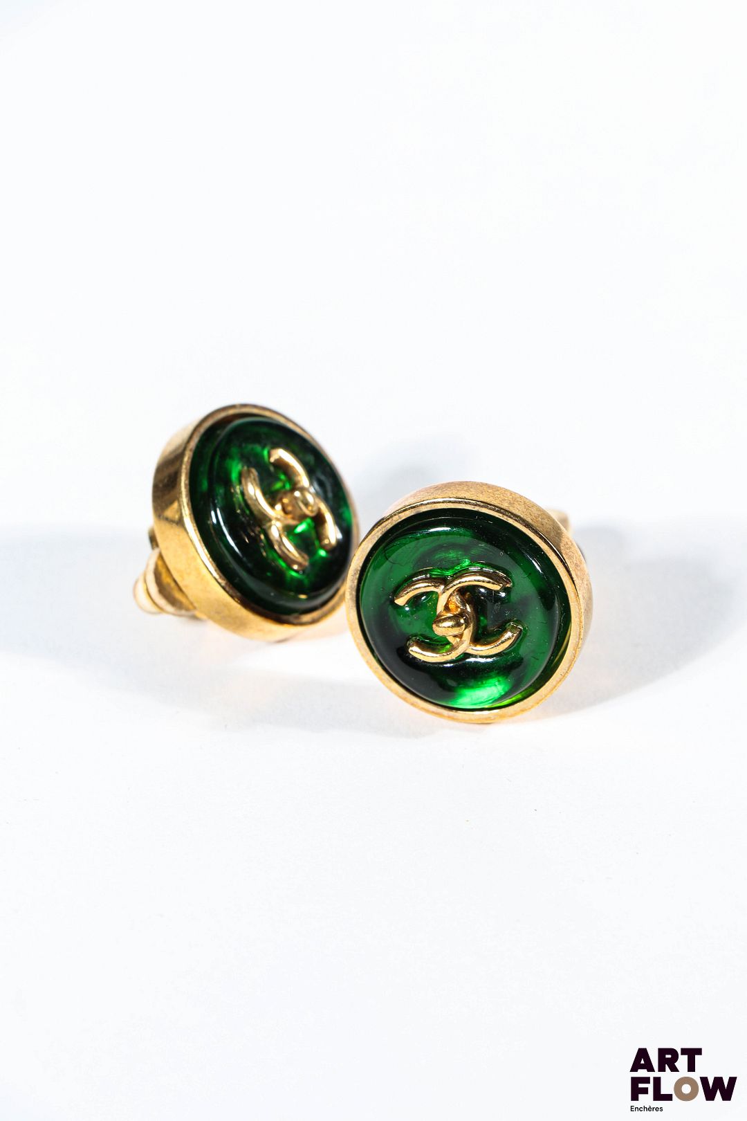 Attribué à CHANEL Paire de clips d'oreille en métal doré et pâte de verre verte centrés du monogramme Chanel D. 2 cm Très bon état général