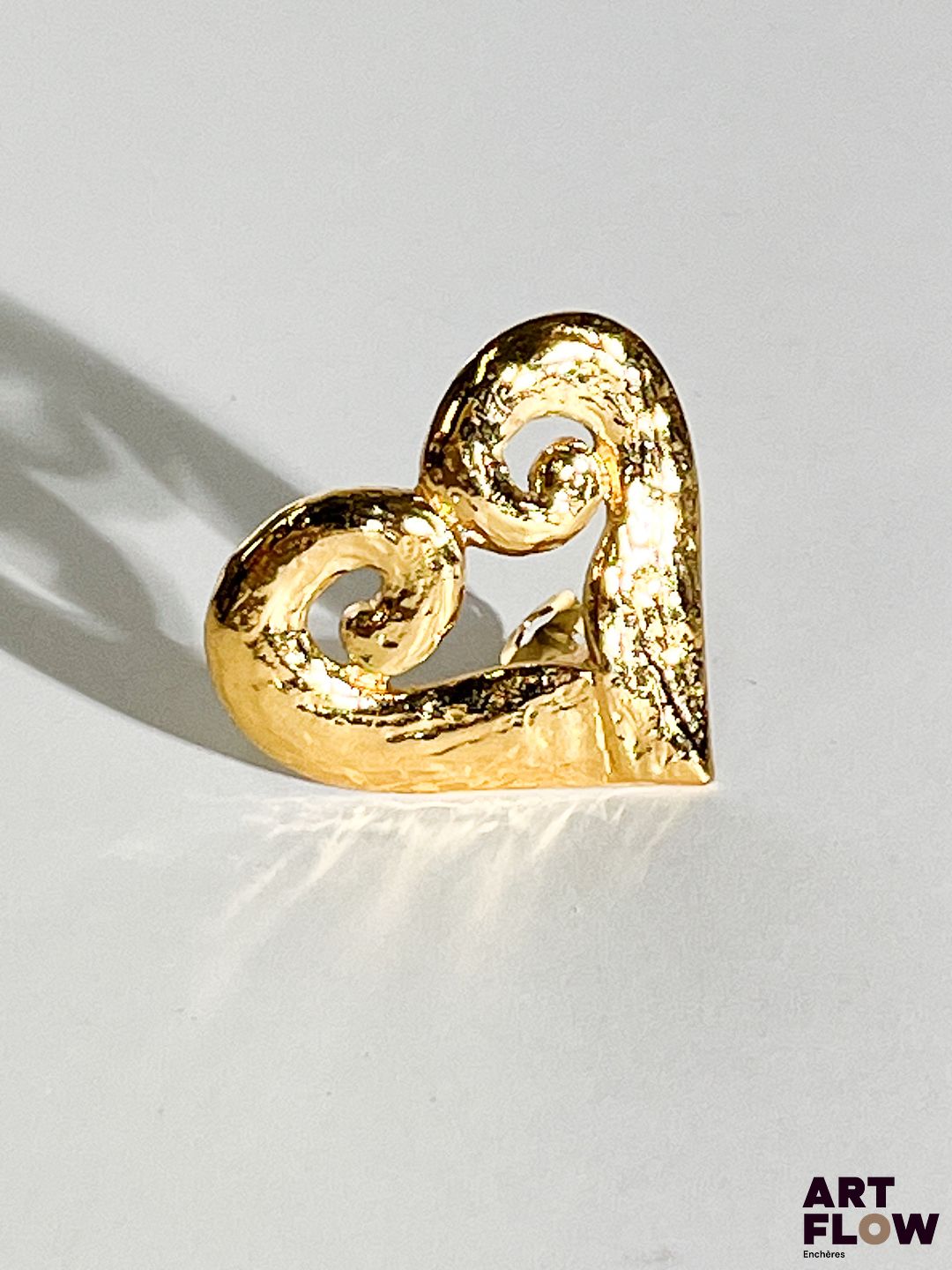 YVES SAINT LAURENT Clip en métal doré représentant un coeur. Signé au dos. Dimensions : H. 4 x L. 4,5 cm