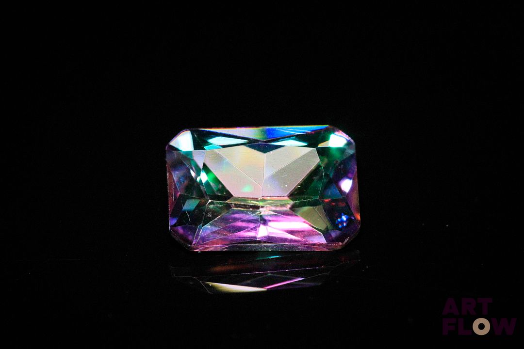 Topaze «Mystique» rectangulaire à pans coupés. Traitement de surface. 4.74 cts. 14.0mm x 10.0mm