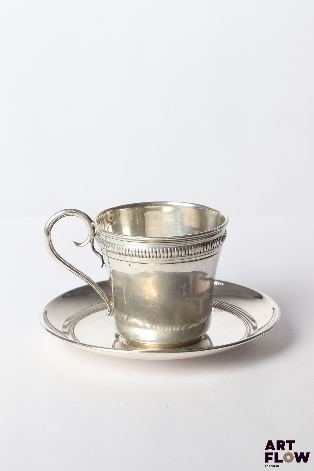 Tasse et sous tasse en argent (Minerve), à décor d'une frise guillochée. Poinçon de maître Gaston Bardiés, 1897/1914, 13 rue des Fontaines, Paris Poids total : 100,65 gr